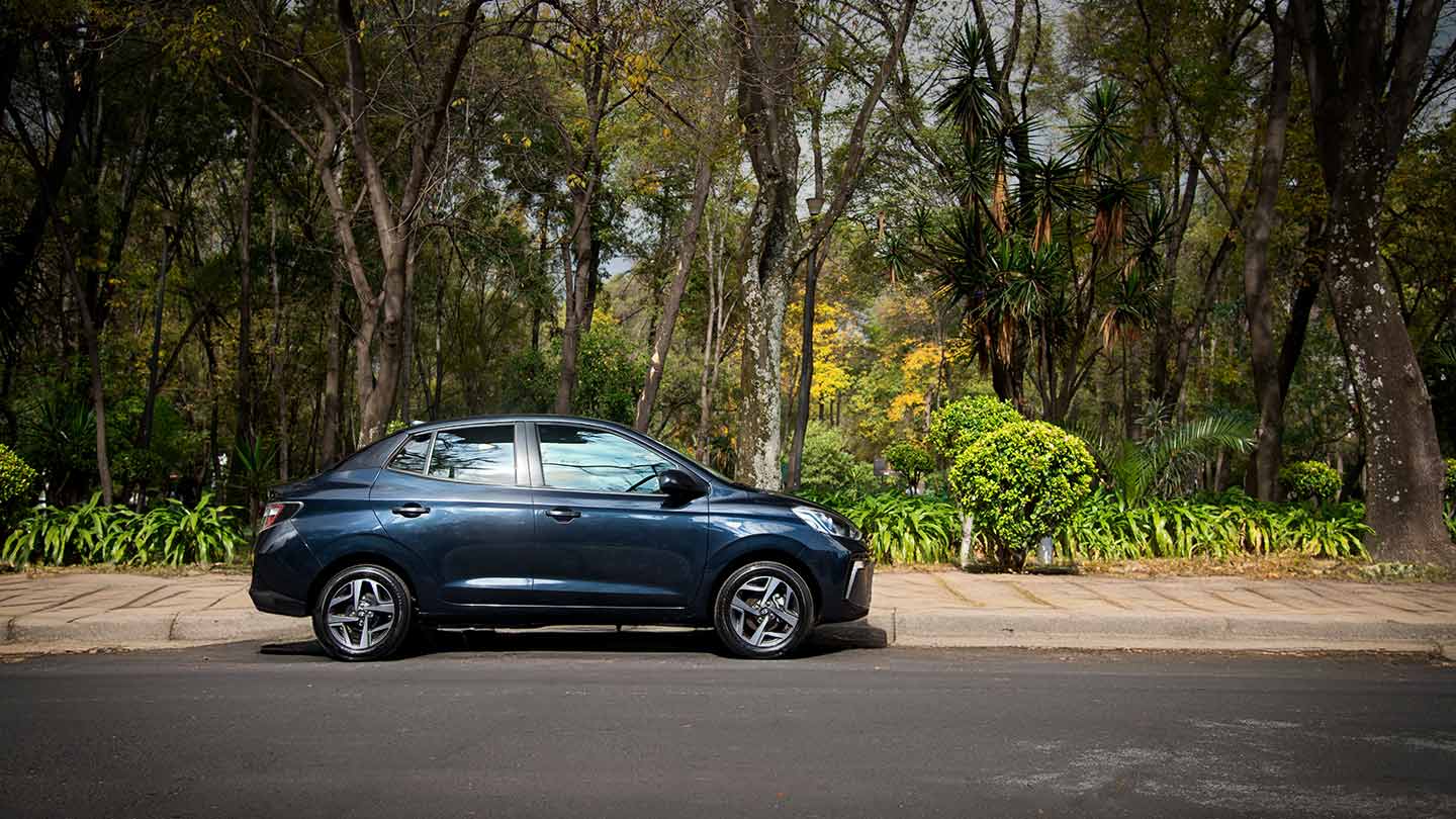 Grand i10 Sedán 2026 color azul estacionado junto a un parque