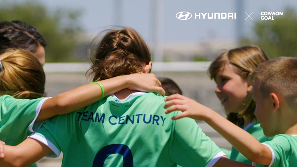 Ni&ntilde;as abrazandose con camisetas de goal century dentro de un partido de soccer