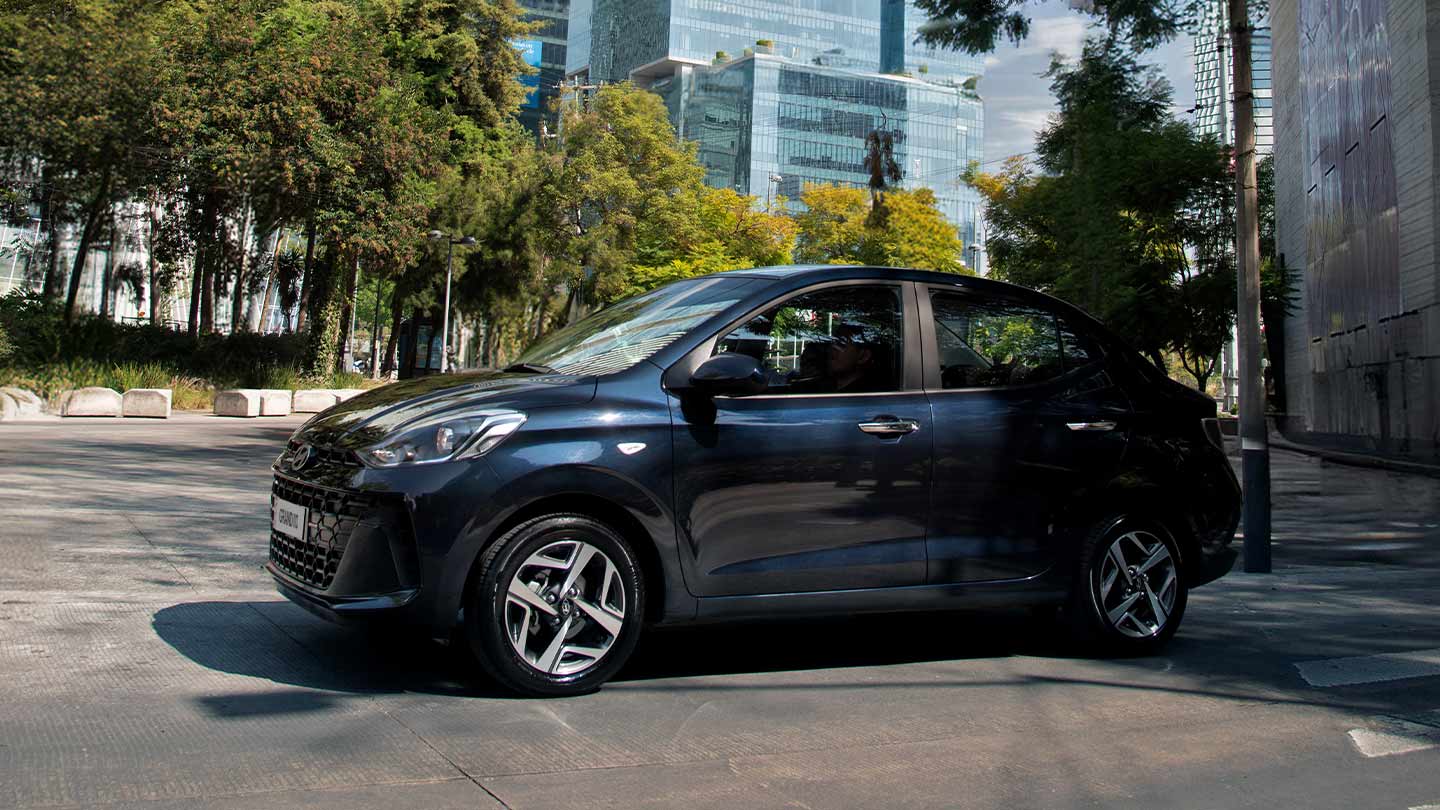Grand i10 Sedán color azul 2026 en zona de edificios